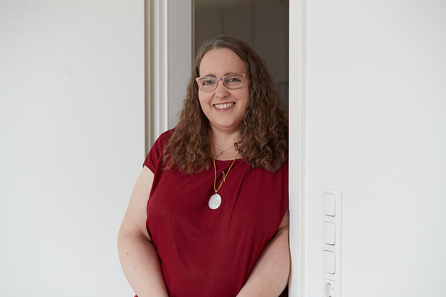 lächelnde Frau mit rotem Oberteil, Halbportrait