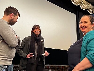 Drei Menschen auf einer Bühne, in der Mitte Dr. phil. Lisa Miebach