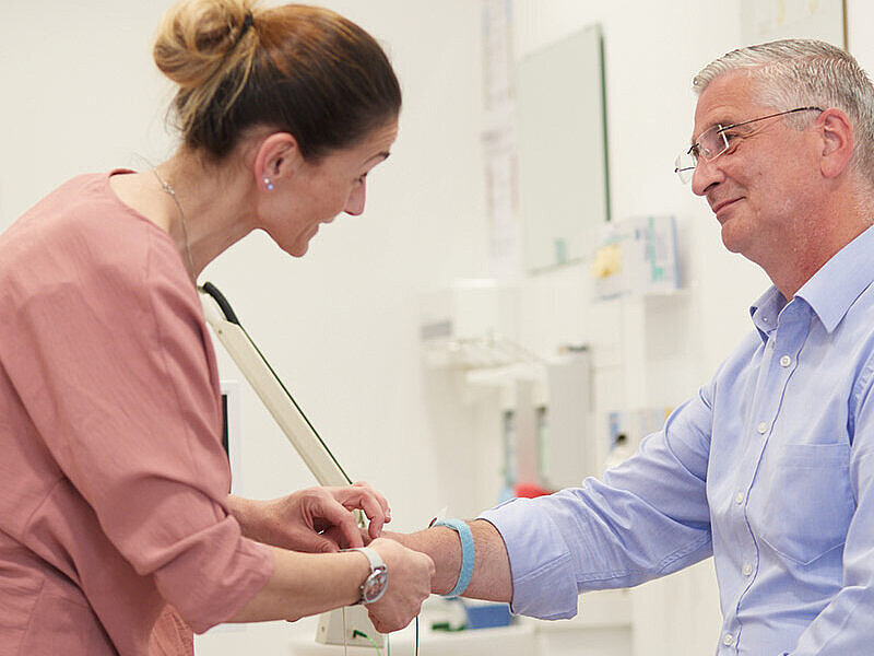 Eine Arzthelferin untersucht einen Patienten im Medizinischen Versorgungszentrum für Neurologie.