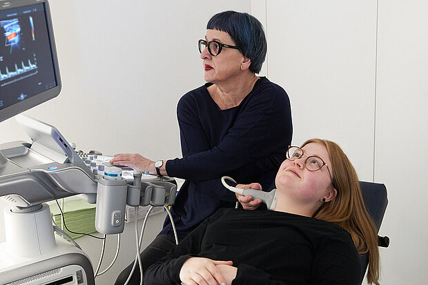 Es wird Ultraschall am Hals einer jungen Frau durchgeführt.