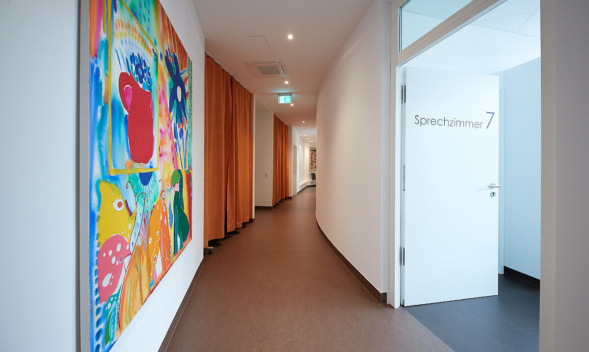 Flur des Neurozentrums Stuttgart mit bunten Bildern an den Wänden.