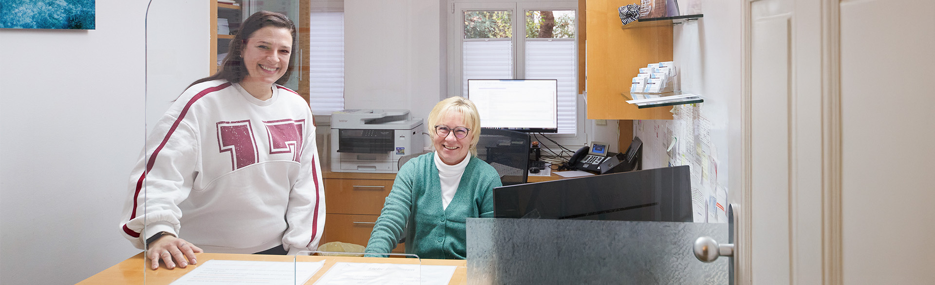 Zwei Ansprechpartnerinnen stehen am Empfang des MVZ für Psychiatrie und Psychotherapie in Berlin-Lichterfelde