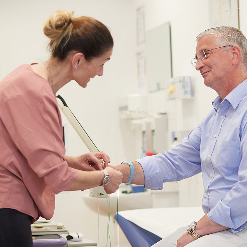 Eine Arzthelferin untersucht einen Patienten im Medizinischen Versorgungszentrum für Neurologie.