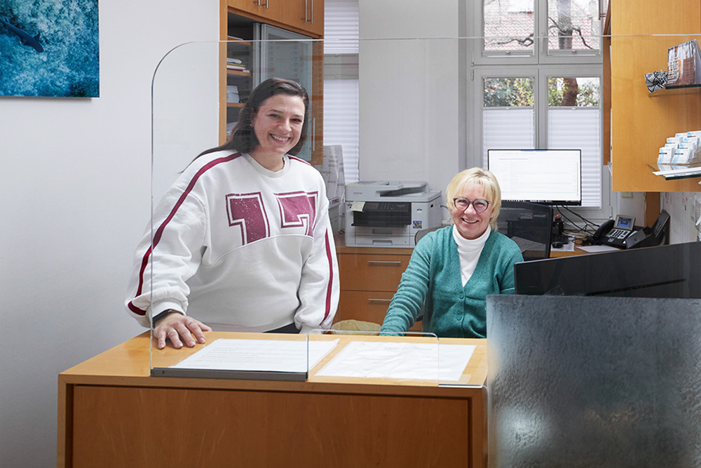 Zwei Frauen stehen und sitzen am Empfang des MVZ Lichterfelde Ost