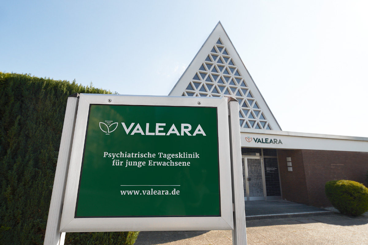 Außenansicht der Psychiatrischen Tagesklinik für junge Erwachsene mit einem Eingangsschild davor.