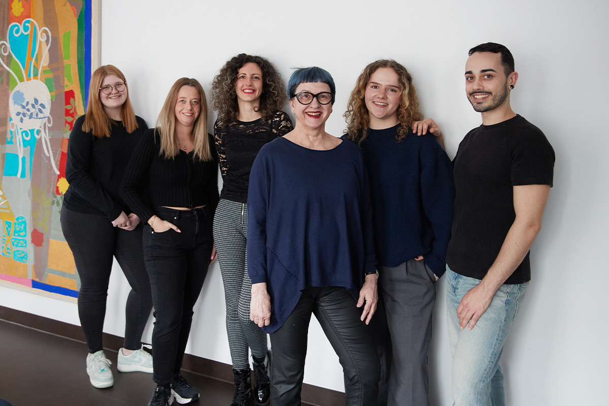 Eine Gruppe von Menschen steht bei VALEARa in einem Raum und lächelt in die Kamera.