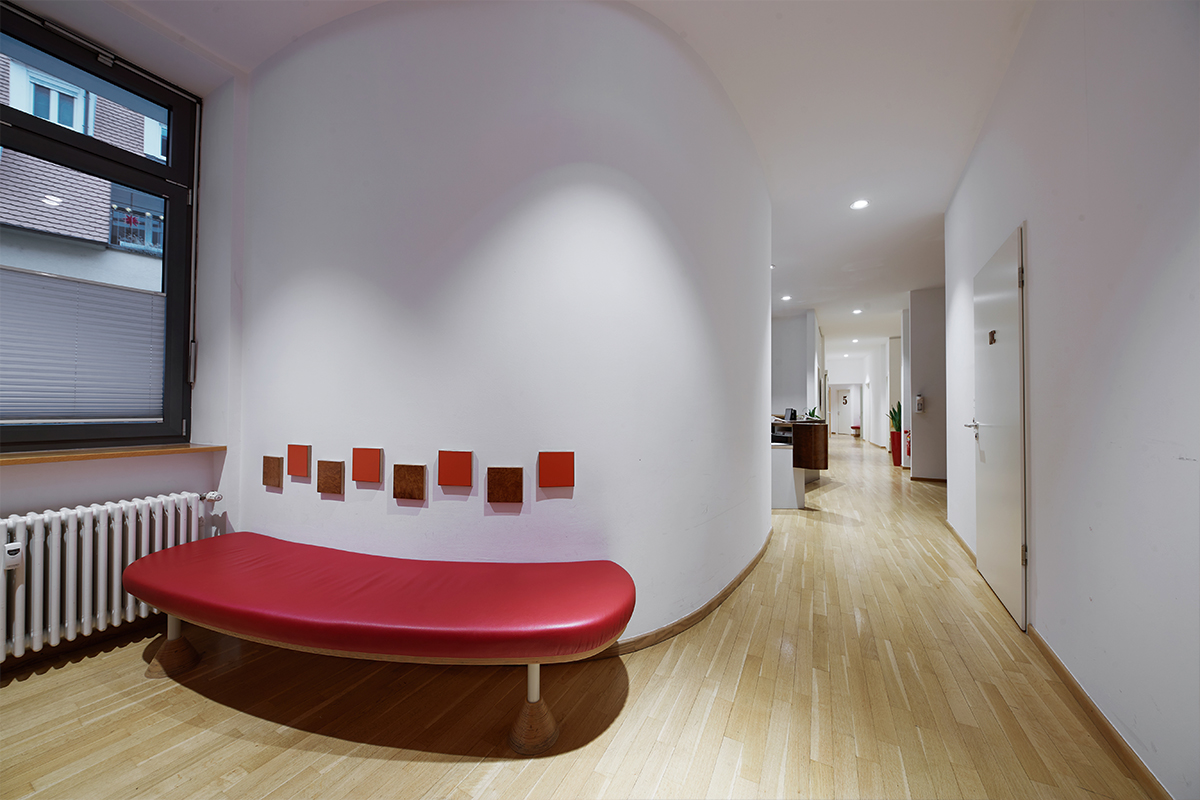 Der Flur und Wartebereich mit einem roten Sofa im Neuro Zentrum Ulm.